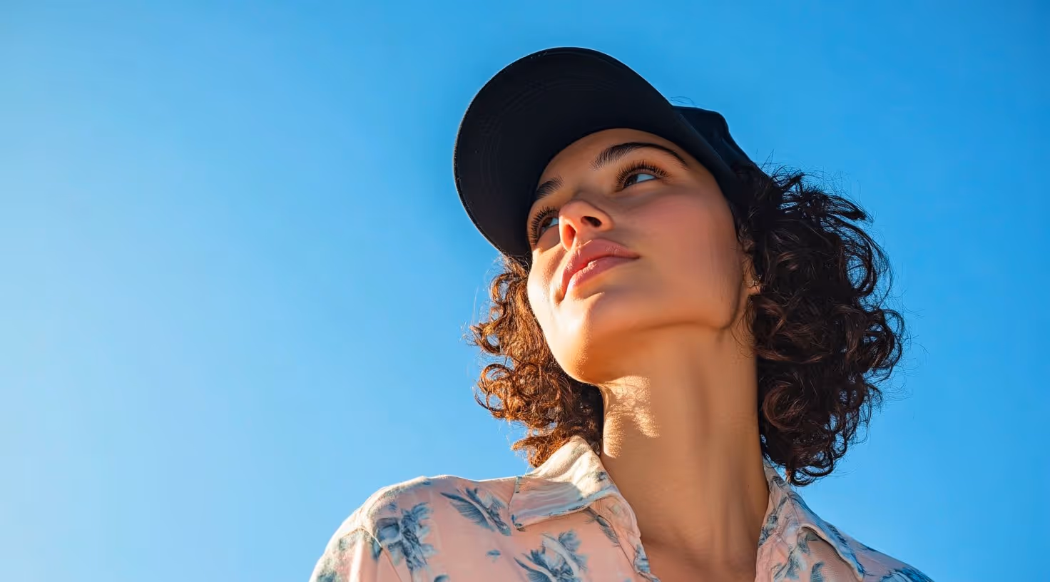 Una ragazza con un cappellino che guarda in alto