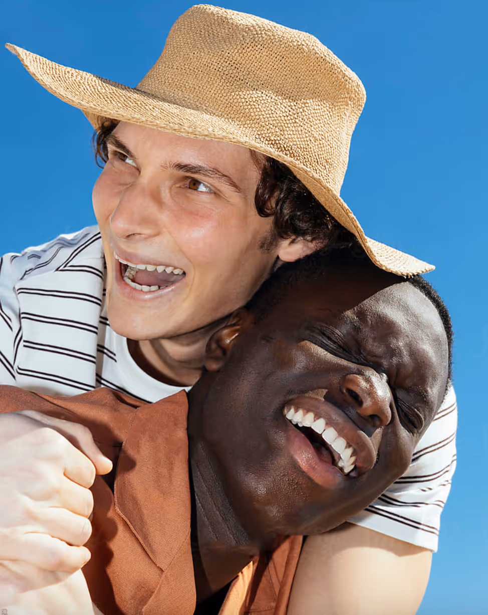 Due amici felici che si abbracciano da dietro.